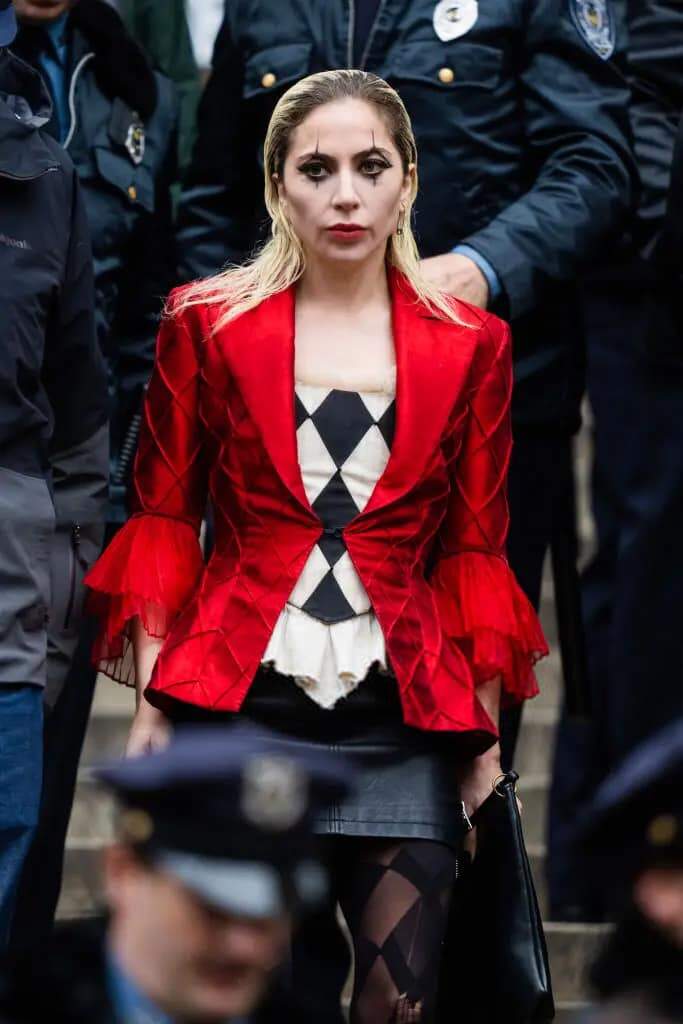 Com figurino preto, branco e vermelho, Lady Gaga encarna Arlequina em cenas de 'Coringa 2'