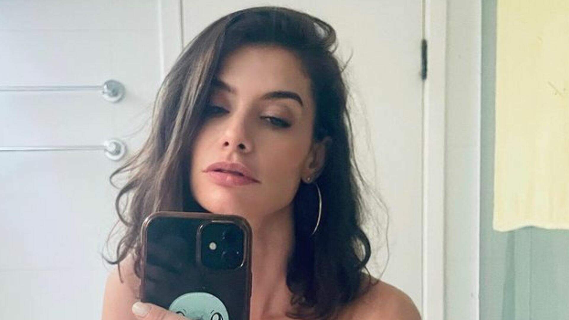 Alinne Moraes abre a blusa em frente ao espelho e quase deixa volume aparecer: “Segurei” - Metropolitana FM